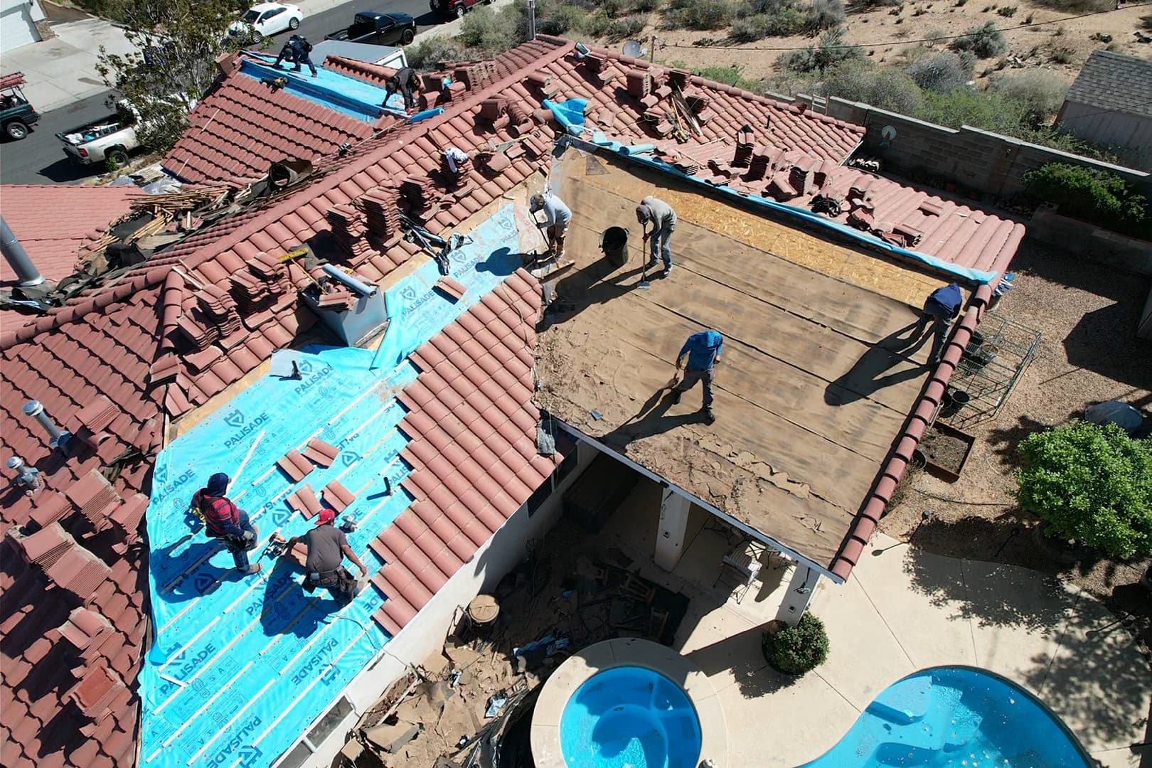 Lobo Roofs crew performing tile roof replacement — aerial drone shot showing active work