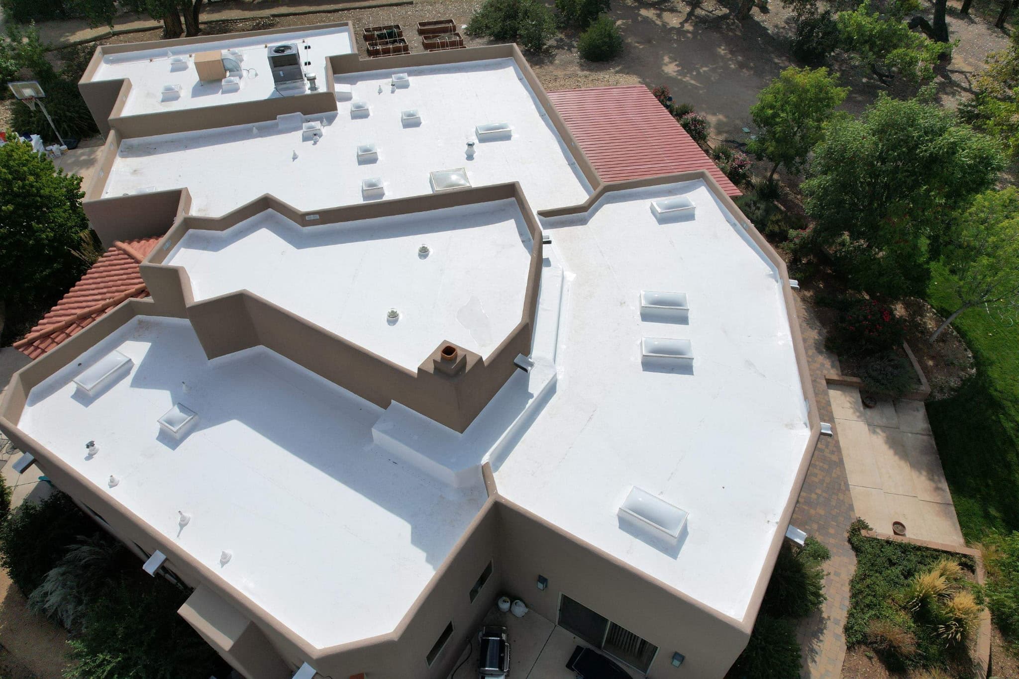 Completed TPO flat roof coating on residential property — aerial drone shot by Lobo Roofs